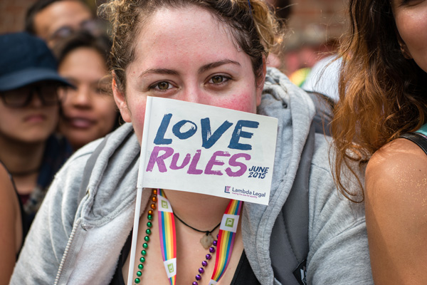 At the Pride March, a supporter of Lamba Legal said it’s time to “let love rule.” Lambda Legal represented four couples who were plaintiffs in the U.S. Supreme Court gay-marriage lawsuit.  Photo by Milo Hess