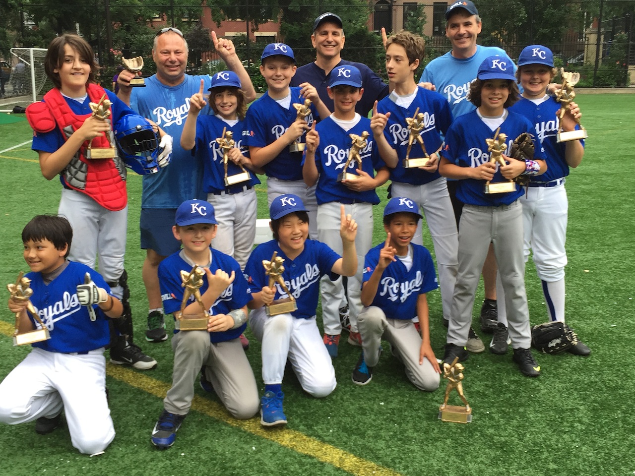 The championship Royals hoist their hardware, front row, from left, Jack Yuen, Eliot Germanson, Thomas Manchester, Finn Kaplan-Moore; second row, from left, Caleb Callahan, Caden Roberts, Stevie Nichol, Nathan Steinfeld, Dylan Hart, Paolo Reilly-Bell, Zane Kleinberg; third row, from left, Larry Roberts, Bruce Steinfeld, Ken Callahan.