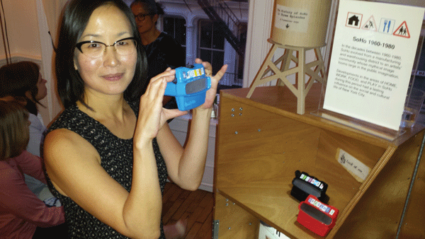 Downtown Express photo by Lincoln Anderson Yukie Ohta models a Viewmaster containing photos from one of three distinct eras of Soho from the cart’s “History” section. 