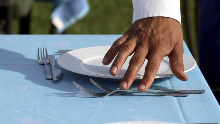 A waiter setting plates.