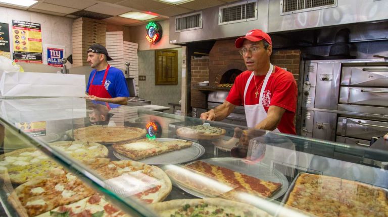 Frank Caruana serves customers in Carlo's Pizzeria in Middle Village on July 12, 2015.