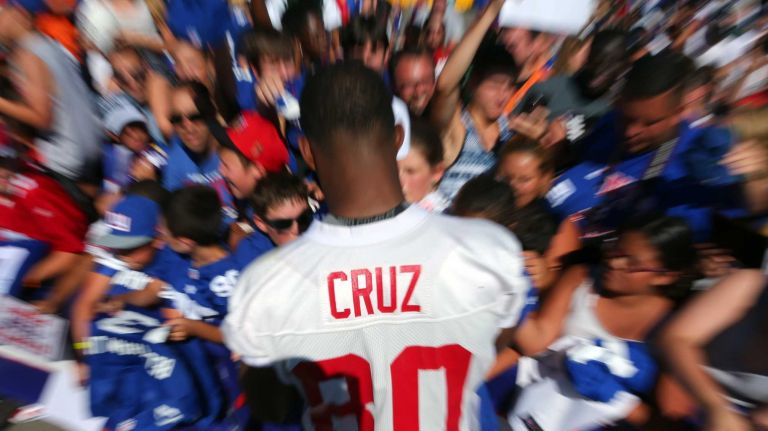 Giants wide receiver Victor Cruz signs autographs for fans after practice during training camp at the Quest Diagnostics Training Center in East Rutherford, New Jersey, on Friday, July 31, 2015.