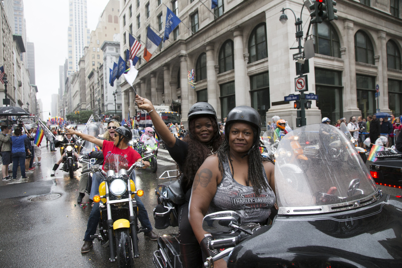 Lesbian motor bikers take the lead as the tradition during annual New York Gay Parade. Despite the bad weather, people enjoy, since the same sex marriage became legal nationwide two days before.