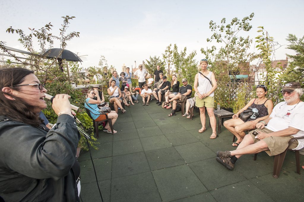 Council member Rosie Mendez speaking to the crowd at the open house for the former squat's new rooftop garden. Photo by Roberto Mercado