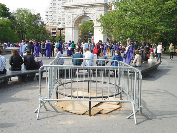 One of the three empty tree pits around the fountain plaza at Washington Square Park. Gates and plywood were put around the hole — making it even more unsightly — to keep parkgoers from tripping over the low railing and injuring themselves.   Photos by Sharon Woolums