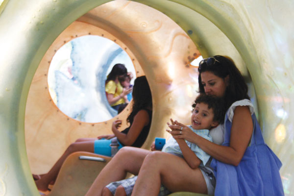 Downtown Express photos by Yannic Rack Sharon Arang with her son, Ari, 4, inside the SeaGlass Carousel. There were long lines Aug. 20 for the opening. 