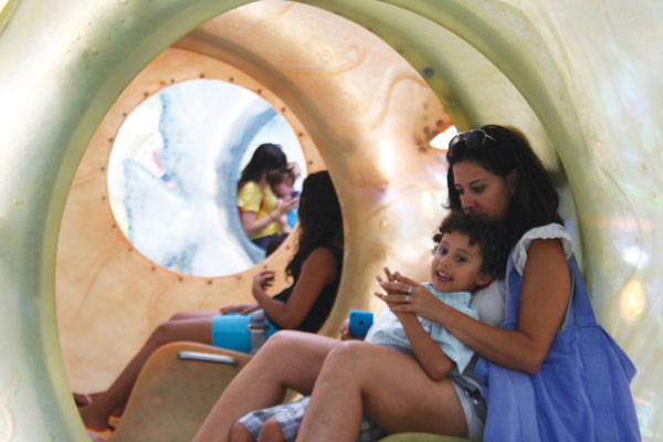 Merry raves flow for fish carousel opening 2 Downtown Express photos by Yannic Rack Sharon Arang with her son, Ari, 4, inside the SeaGlass Carousel. There were long lines Aug. 20 for the opening.