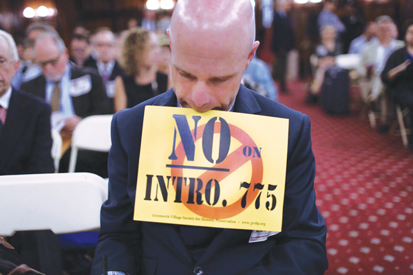 Andrew Berman of G.V.S.H.P jotted down notes while still displaying his “No on Intro. 775” sign at last week’s hearing at City Hall.  Photo by William Alatriste / NYC Council
