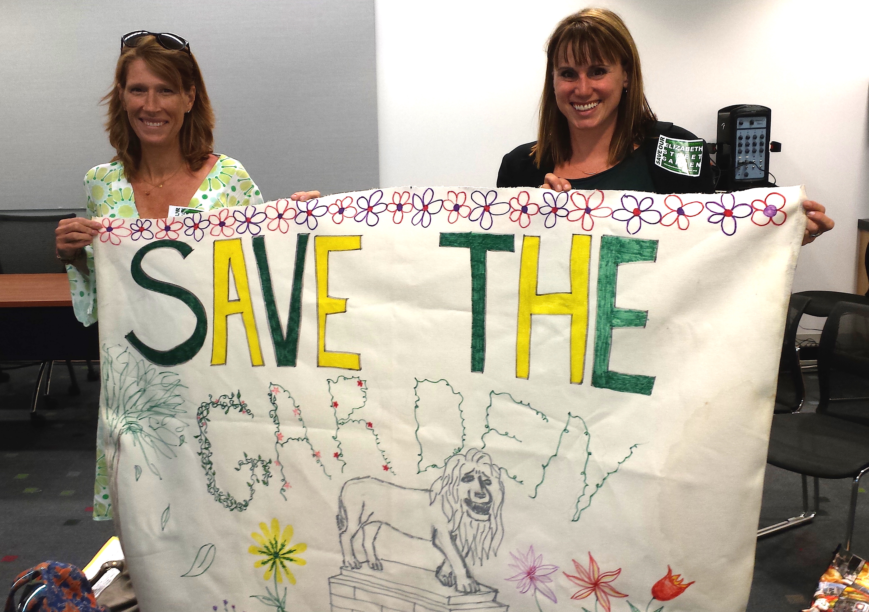 Garden leaders Emily Hellstrom, left, and Jeannine Kiely proudly displayed a banner for the Elizabeth St. Garden.