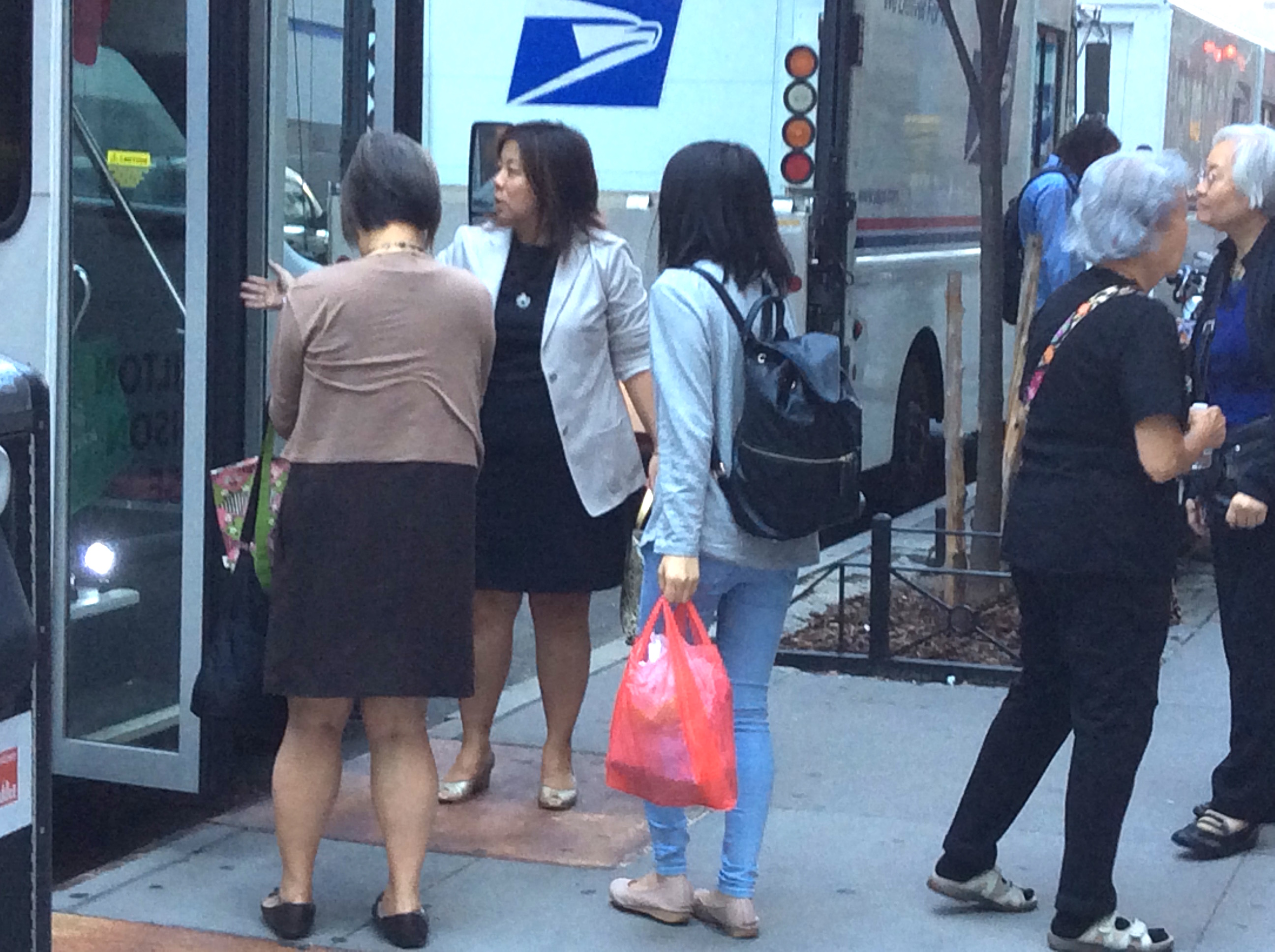 Fay Matsuda, at left with her back to the camera, the program director at Hamilton-Madison House, stands by as seniors from the Chinatown / Lower East Side settlement house exit a van that brought them to the hearing. The settlement house is located a mile away from the Elizabeth St. Garden. Photo by Lora Tenenbaum