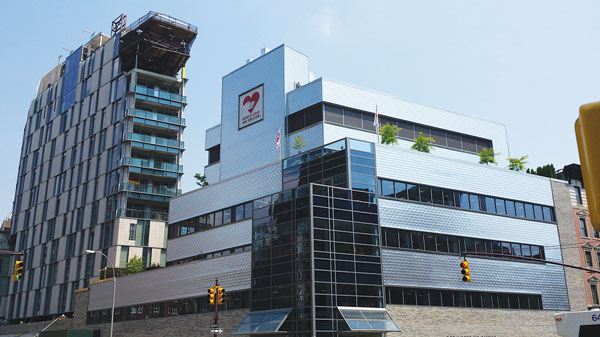 The exterior of the new God’s Love building features distinctive-looking aluminum panels. The developers of the neighboring building to the left bought $6 million worth of development rights from the meals provider.