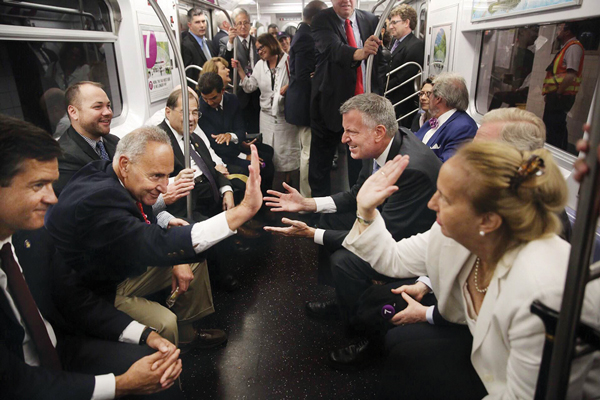 Riding the 7 train to Hudson Yards, clockwise from bottom left, state Senator Brad Hoylman, U.S. Senator Chuck Schumer, City Councilmember Corey Johnson, Congressmember Jerrold Nadler, Councilmember Ydanis Rodriguez — chairperson of the Council’s Transportation Committee — Mayor de Blasio, Assemblymember Richard Gottfried (hidden from view) and Borough President Gale Brewer.  Photo by William Alatriste / NYC Council