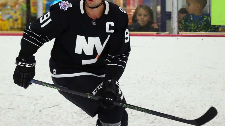 John Tavares #91 of the New York Islanders skates with youth hockey players while modeling the team's new third jersey at Iceworks on Sept. 15, 2015 in Syosset.