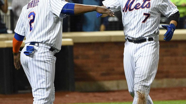 New York Mets second baseman Juan Uribe congratulates catcher Travis d'Arnaud on his two-run home run against the Miami Marlins during the sixth inning of a game at Citi Field on Monday, Sept. 14, 2015.