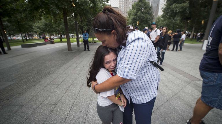 Michelle Calabro comforts her daughter, 8-year-old Gianna Calabro, as they remember Gianna's uncle, NYC Firefighter Salvatore Calabro, who died during the Sept. 11 terror attacks on Manhattan. Friends and families gathered at Ground Zero on Sept. 11, 2015 to honor and remember those killed 14 years ago.