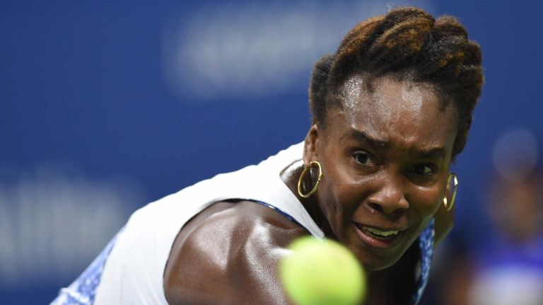 Venus Williams returns to Serena Williams during the women's singles quarterfinals at the U.S. Open tennis tournament on Tuesday, Sept. 8, 2015.
