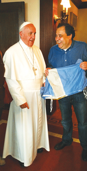 Restaurateur Ismael Alba, holding an Argentinian flag, speaking with Pope Francis after the lunch. Alba asked the pope to bless the banner, which he proudly took back to hang in his restaurant.