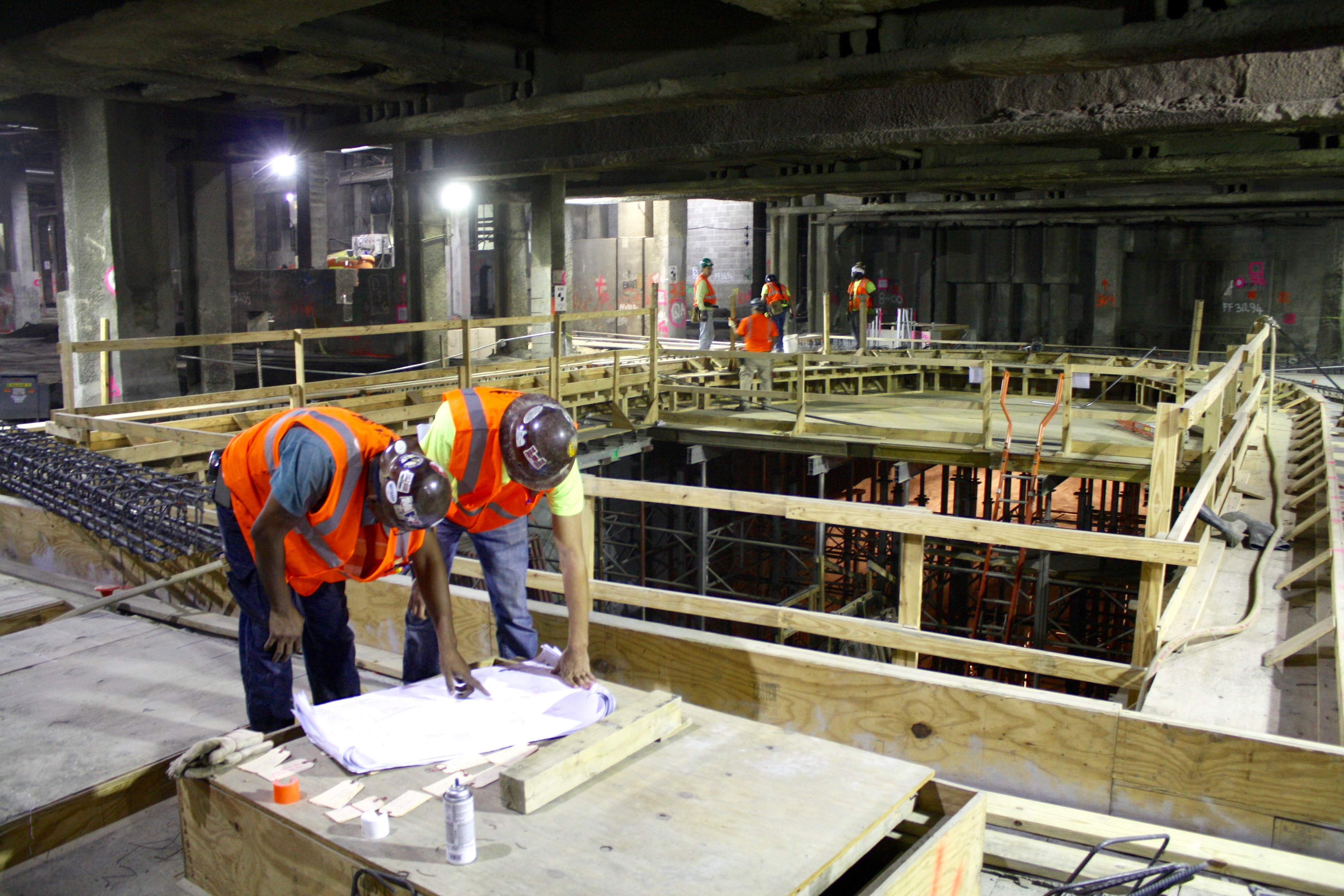Workers studying construction plans at the concourse level of the new LIRR terminal, which is scheduled to open by December 2022. | YANNIC RACK 