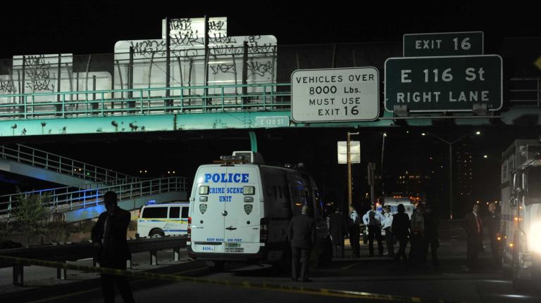 NYPD investigators gather Tuesday, Oct. 20, 2015, at East 120 Street and the FDR Drive in Manhattan, where police said they recovered two firearms. The scene is just blocks from where Officer Randolph Holder, 33, of Brooklyn was fatally shot in the head during a foot pursuit in East Harlem.