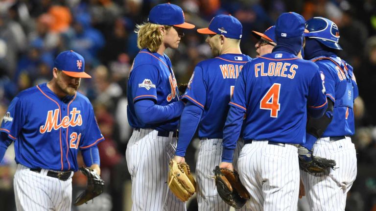 New York Mets pitching coach Dan Warthen (59) talks to starting pitcher Noah Syndergaard (34) in the sixth inning as the infield comes to the mound during Game 2 of the NLCS against the Chicago Cubs at Citi Field on Sunday, Oct. 18, 2015.