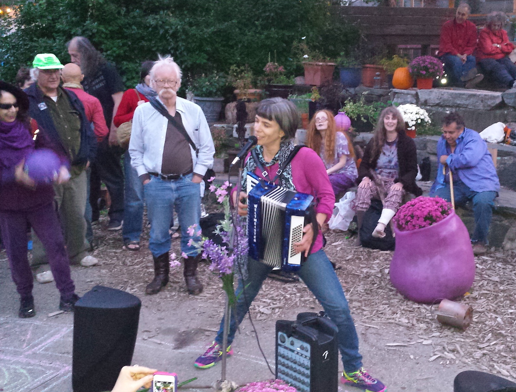 A woman from the Upper West Side who met Adam Purple years ago put her memories of him into a song. Listening, from left, were WBAI radio host Fran Luck (juggling a purple dodge ball), environmental attorney Joel Kupferman and Yippie and ibogaine activist Dana Beal. At far right is Jimmy Simopoulus, aka Jimmy Sims.