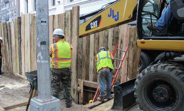 Photo by Tequila Minsky Workers at the trench on Washington Square East earlier this month, a few days after the two old burial vaults were found.