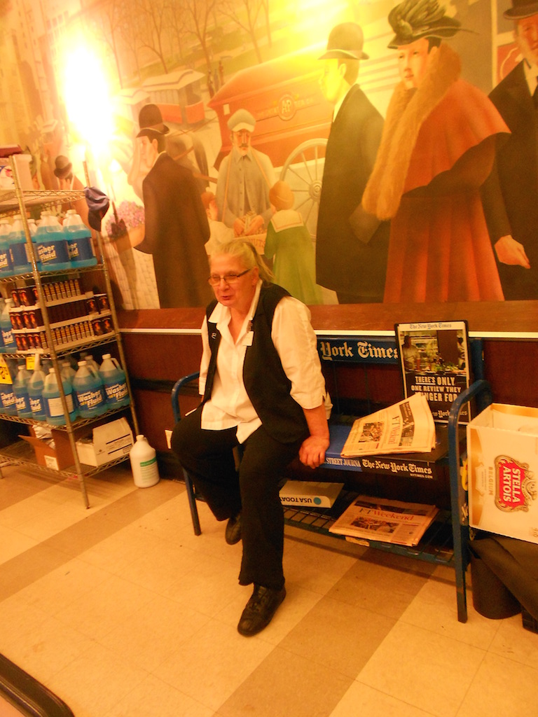 Sophie Henderson, a part-time night manager at the Union Square Food Emporium for 17 years, resigned without severance pay after the store’s sale. Above, she sat on the store’s news rack — where The Villager can be found — the weekend before the store’s sale.