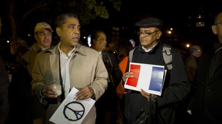 New York State Senator Adriano Espaillat, left, mourns with residents holding candles in Bennett Park in Manhattan on Nov. 15, 2015, in solidarity with France after attacks in Paris.
