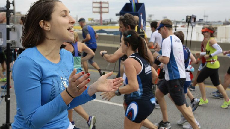 Monica Merlis cheers on runners as they pass the halfway point of the New York City Marathon in Brooklyn on Nov. 1, 2015.
