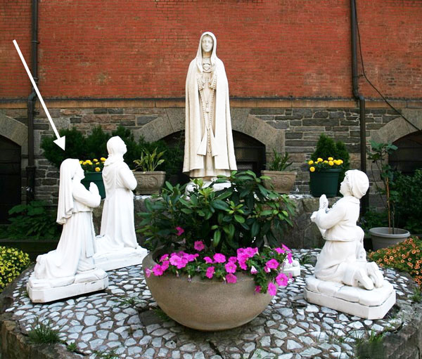 The statue of Jacinta (indicated by arrow) was stolen from St. Anthony’s Our Lady of Fatima shrine on Nov. 10. The church is hoping for an “apparition” of the statue — as in, its return — along with that of Jacinta and her sisters’ sheep that was stolen, too.