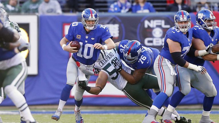 Eli Manning #10 of the New York Giants is taken down by Mike Catapano #53 of the New York Jets at MetLife Stadium on Sunday, Dec. 6, 2015 in East Rutherford, N.J.