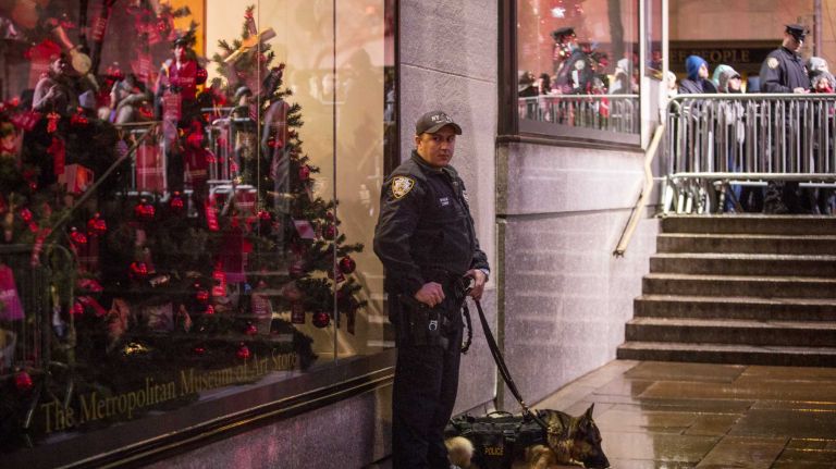 An NYPD officer and his police dog keep watch at the Rockefeller Center Christmas tree lighting ceremony in midtown Manhattan on Dec. 2, 2015.