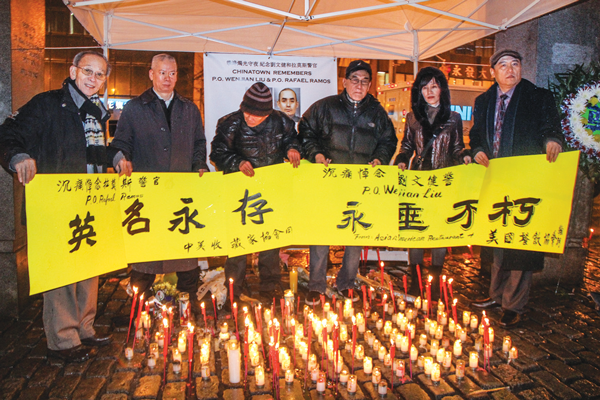 Chinatown restaurateurs held up a banner that said Officer Rafael Ramos’s “name will live forever” and Officer Wenjian Liu “becomes immortal.” 