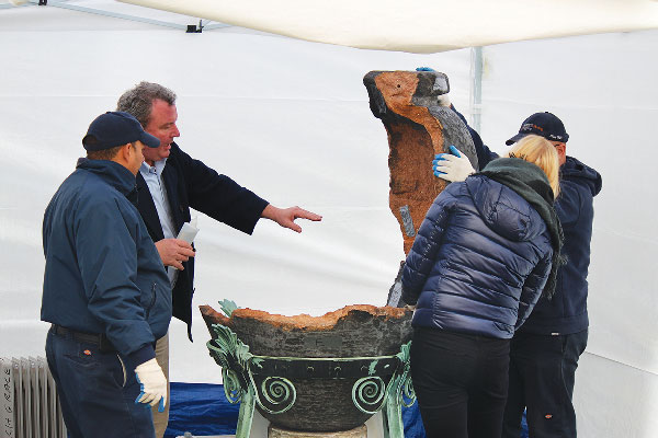 Photos courtesy center art, ltd. Conservators Lansing Moore (holding a bottle of Hextal epoxy) and Melissa Barton, right, and a team of riggers  reassembling the renovated Roman urn in the Grace Church yard last Thursday. The plan was to let the epoxy holding the urn’s pieces together “cure” for a few days, before removing the protective white tent over the urn.