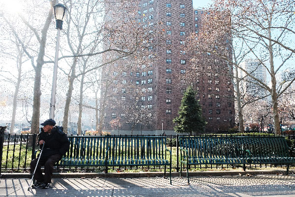 Photo by Jonathan Alpeyrie The Smith Houses on the Lower East Side had been earmarked for infill towers under Mayor Bloomberg, and possibly could be again under Mayor de Blasio. Above, a resident relaxed on a bench on the complex’s airy, light-filled grounds.