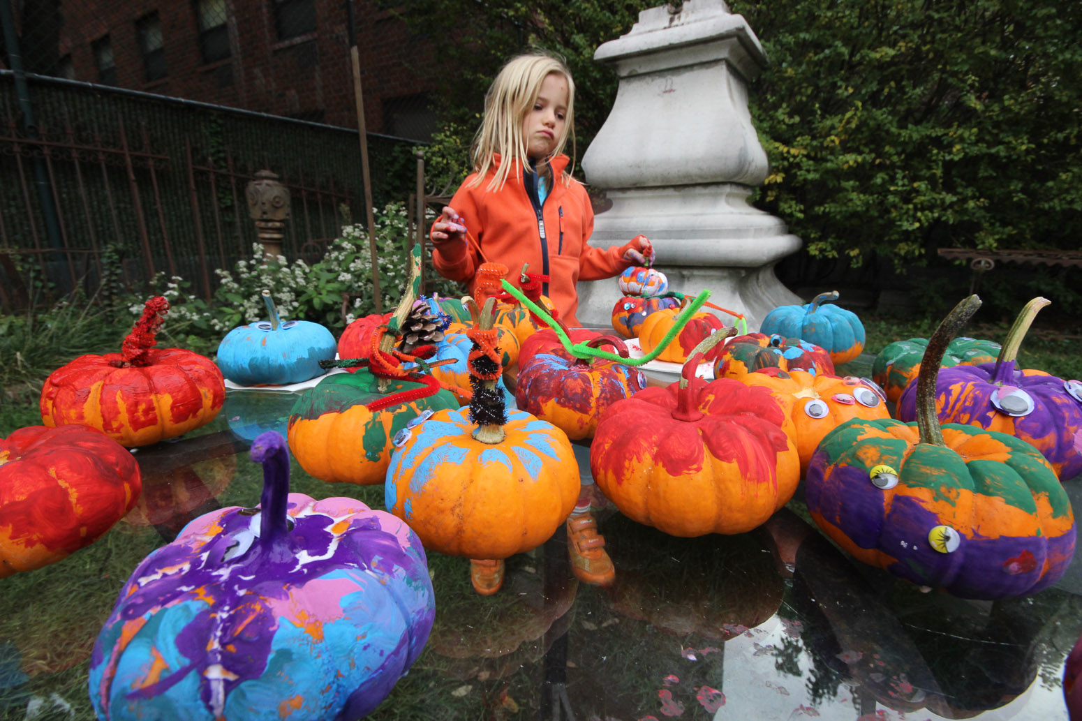 A young girl amid festive pumpkins that gardeners had painted at the Elizabeth St. Garden’s annual Harvest Fest in October.  File photo by Tequila Minsky