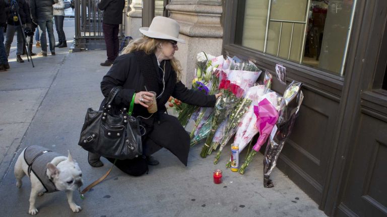 A David Bowie fan places flowers outside of his apartment building in lower Manhattan on Jan. 11, 2016.