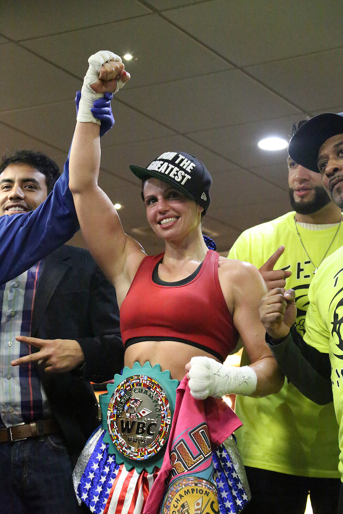 Declared the winner, Alicia Napoleon proudly wears the WBC championship belt.
