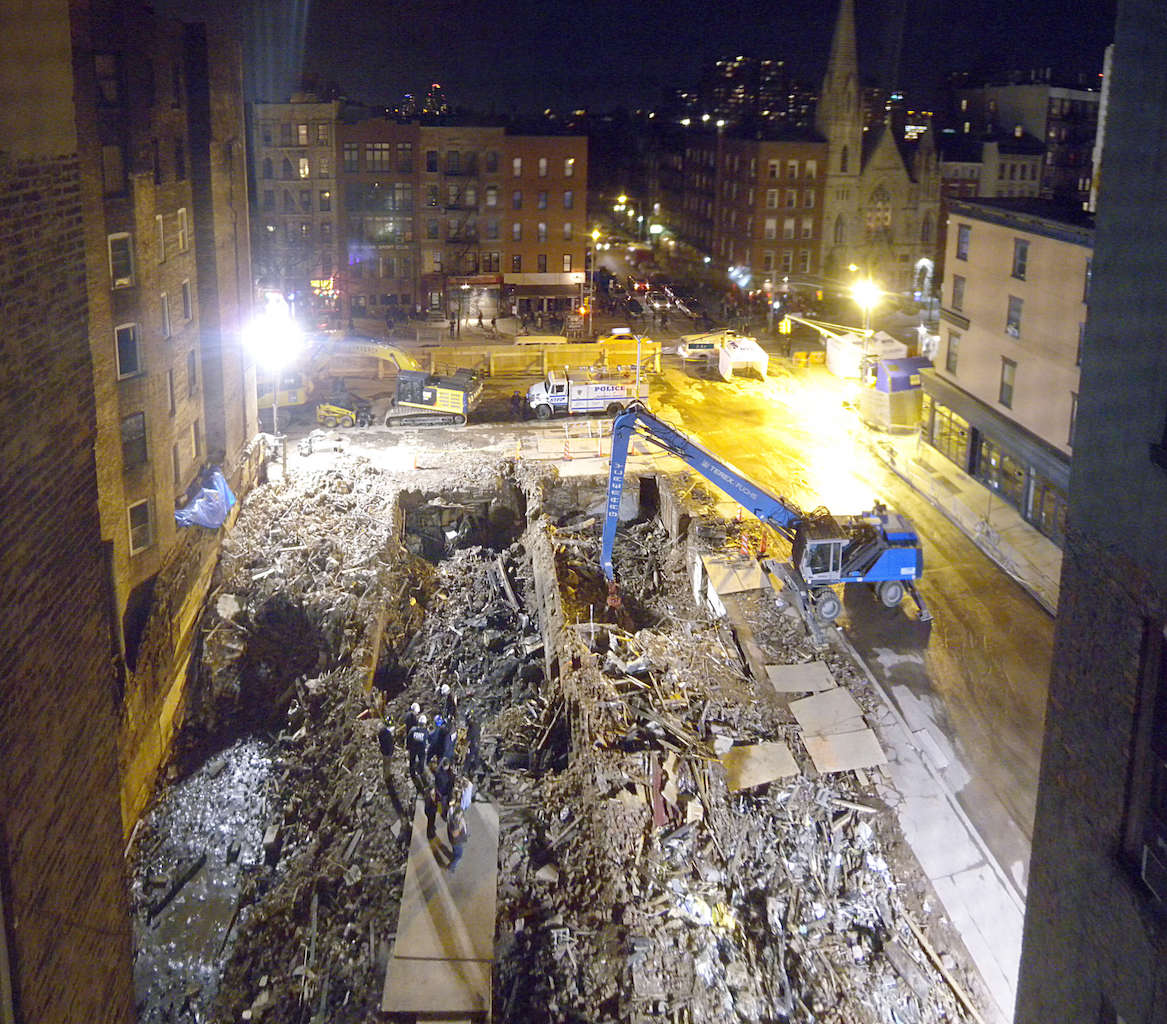 A photo taken by a Community Emergency Response Team (CERT) volunteer from the  E. Seventh St. building just west of the explosion site, showing the three craters left where the tenements had stood.  