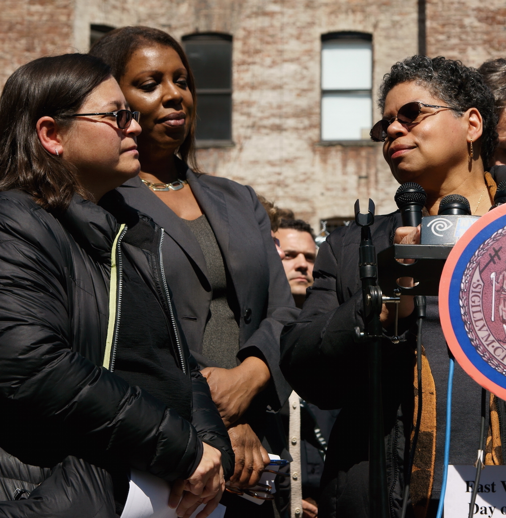 At the Day of Remembrance ceremony, Mildred Guy, a displaced tenant from the former 119 Second Ave., spoke about the apartment her family used to call “Mommy’s Home,” as from left, Councilmember Rosie Mendez and Public Advocate Letitia James listened.  Photo by Patrick J. Eves 