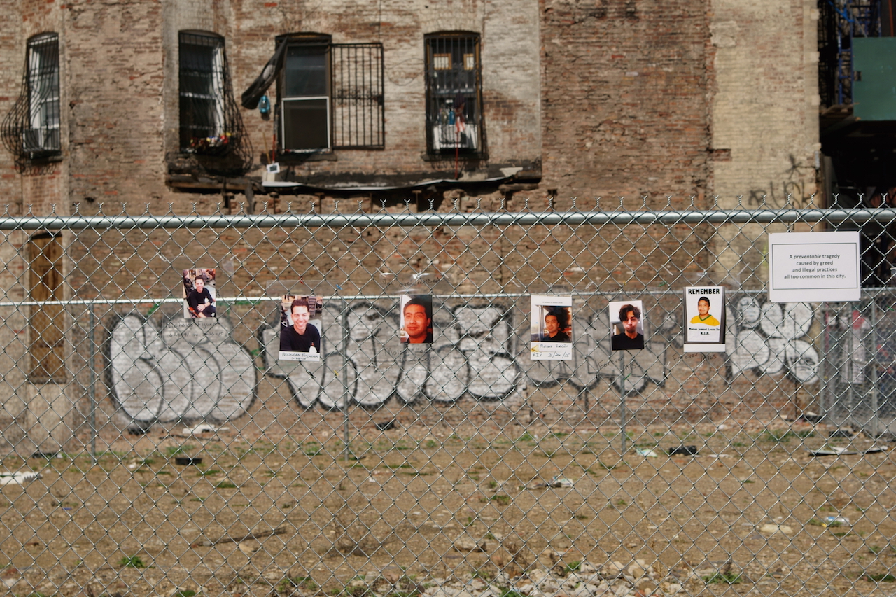 Photos of the disaster's two victims hang on the fence around the barren site. Photo by Tina Benitez-Eves