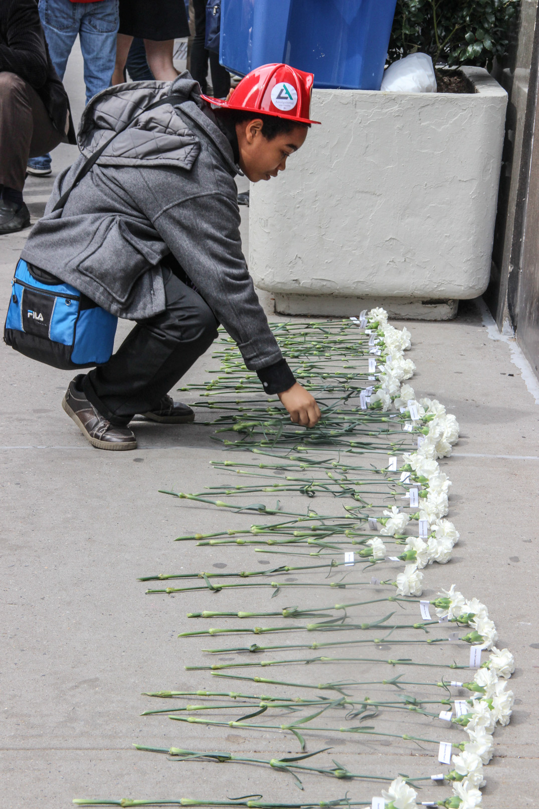 White flowers were laid side by side on the sidewalk outside the Brown Building, one for each of the tragic fire's 146 victims.