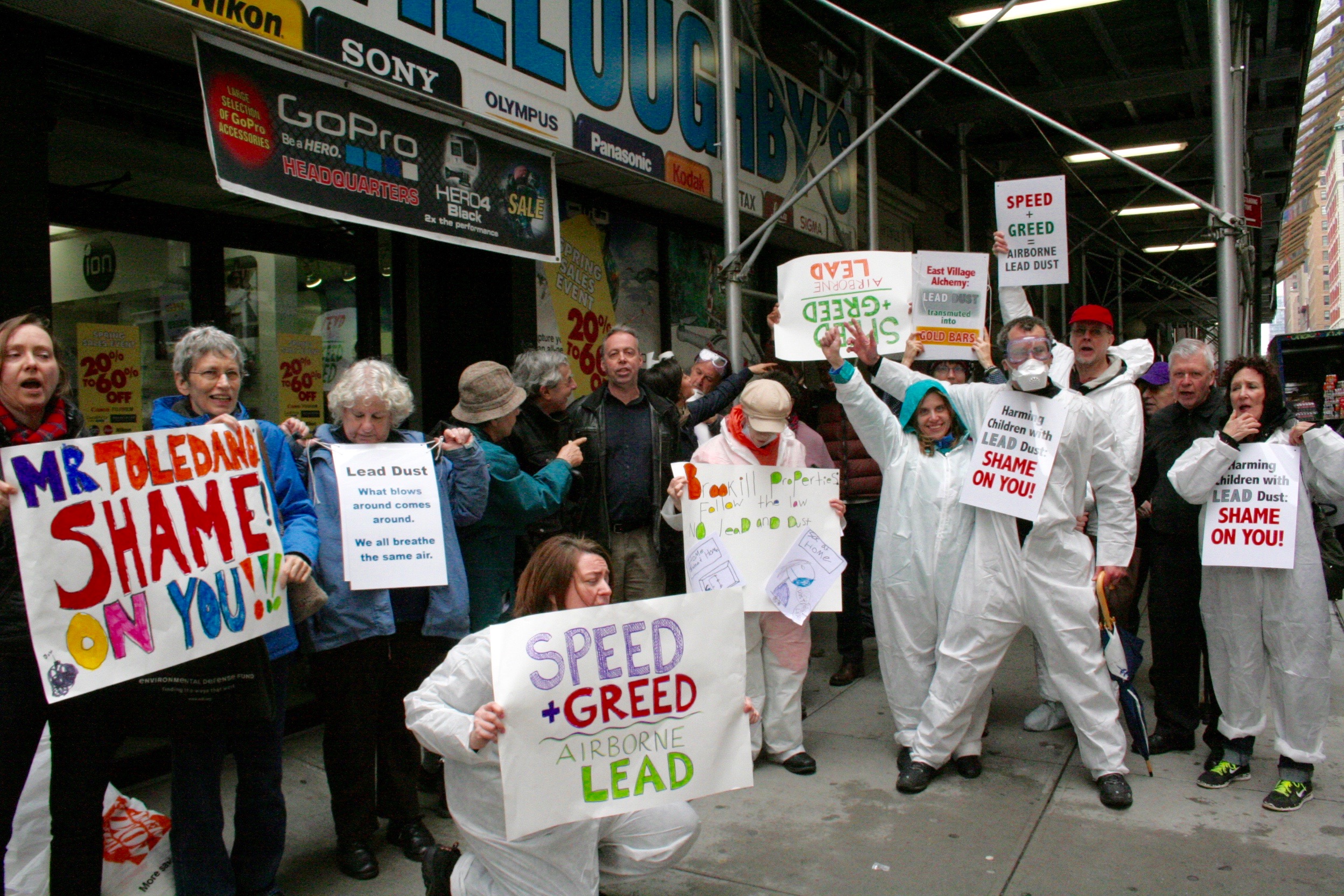 Wearing hazmat suits, tenants from three East Village buildings rallied outside the Union Square-area offices of their landlord, Raphael Toledano, last week, calling on him to use legally required lead-abatement procedures.  Photos by Yannic Rack