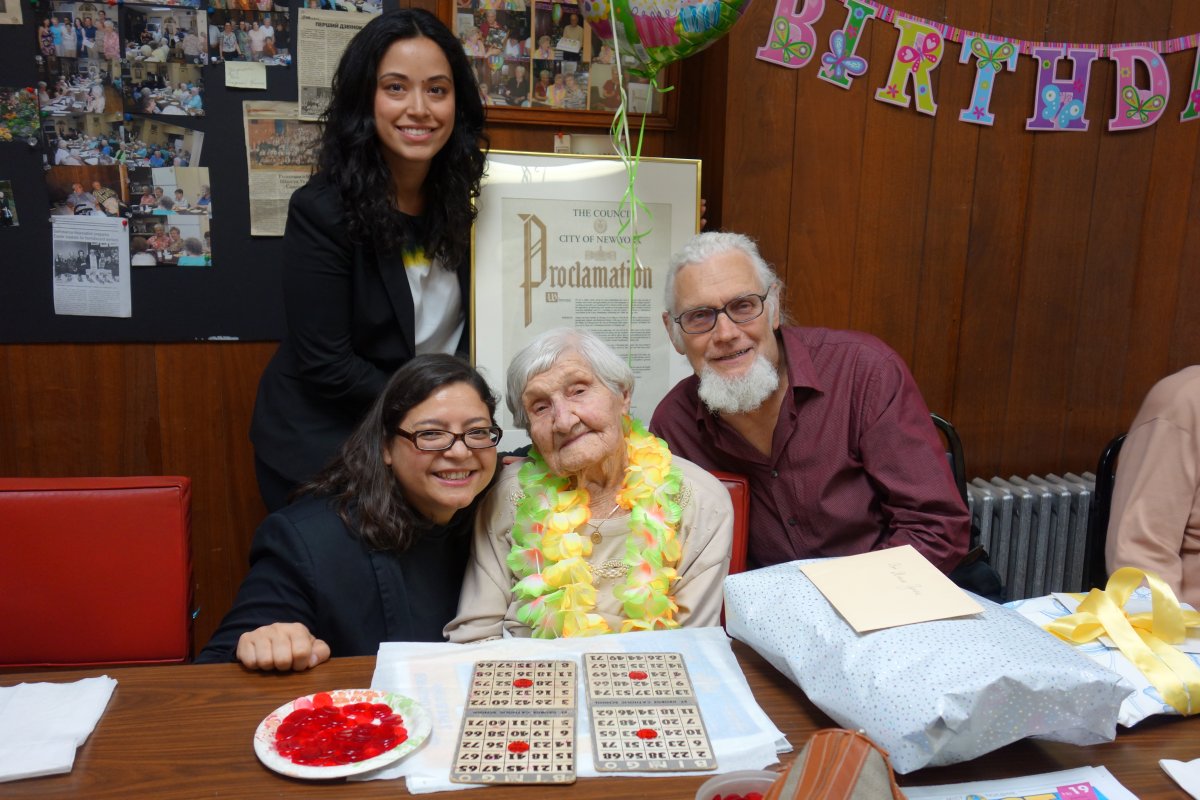 Presenting Teklya Husiak with a City Council proclamation were Councilmember Rosie Mendez, kneeling, and her aide Carlina Rivera, holding proclamation. At right is Husiak’s son John.  Photo by John Blasco