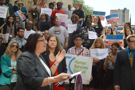 The Underfunding of Nuts and Bolts at NYC’s Non-Profits 2 Beatriz Diaz Taveras, executive director of Catholic Charities Community Services, speaks about the need for more city funding for non-profits at a May 26 City Hall rally as West Side Councilmember Helen Rosenthal looks on. | JACKSON CHEN
