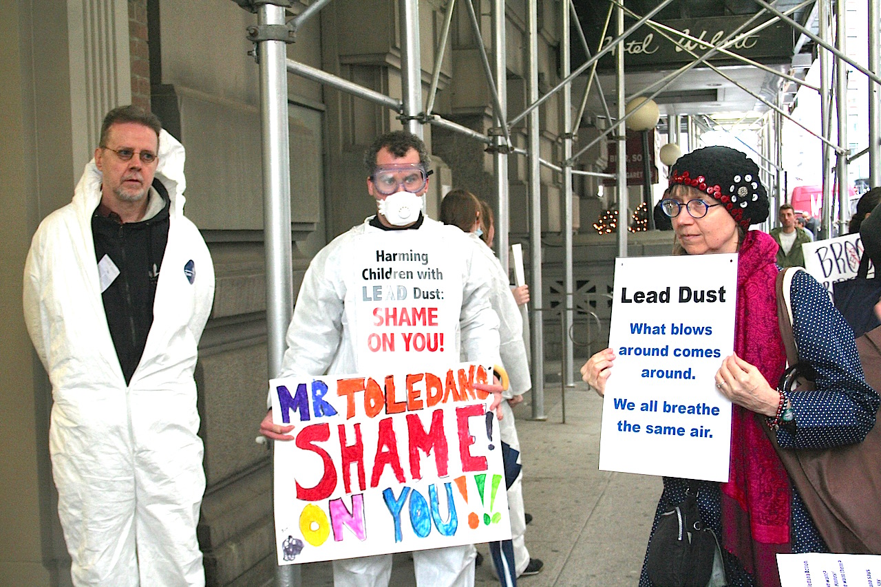 Tenants from three Toledano-owned East Village buildings, some wearing hazmat suits and dust masks, protested outside their landlord’s Union Square-area offices last month, urging him to use legally required lead-abatement procedures. Photo by Yannic Rack