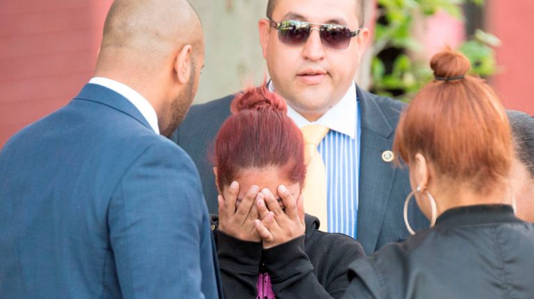 A grandmother was fatally stabbed and her 9-year-old granddaughter injured inside a Bronx apartment building, police said. Pictured: The girl's mother talks to detectives outside of her apartment building on May 11, 2016.