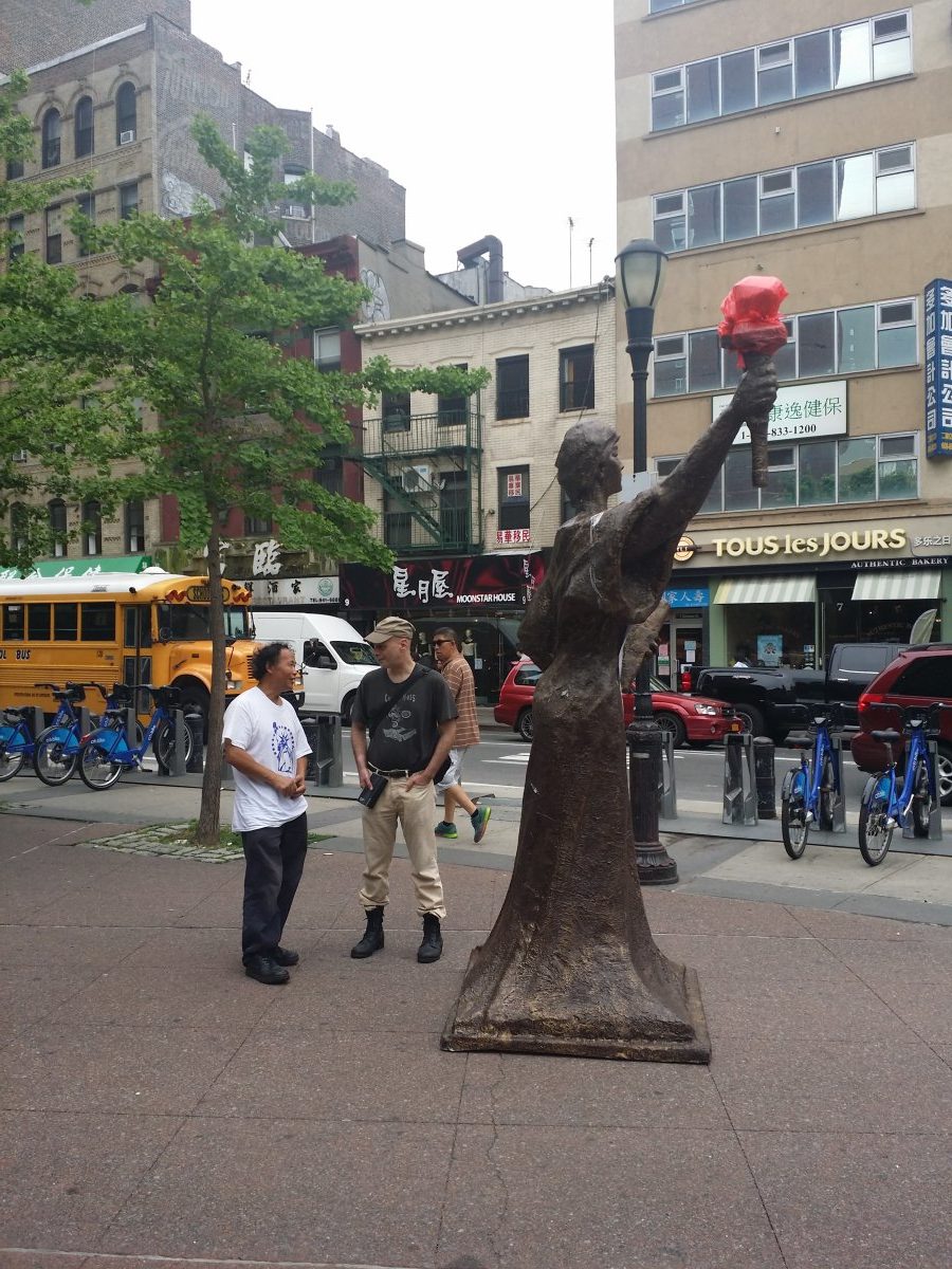 Reporter Bill Weinberg, right, speaking with artist Chen Weiming next to Chen’s “Goddess of Democracy” in Chinatown when the statue was recently brought to New York.