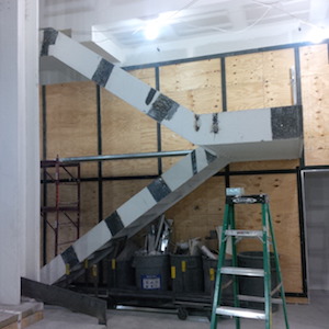 A staircase takes visitors to the newly installed balcony (in a later phase of its construction, wire mesh further contributes to the theatre’s newfound sense of open space). Courtesy Irish Rep.