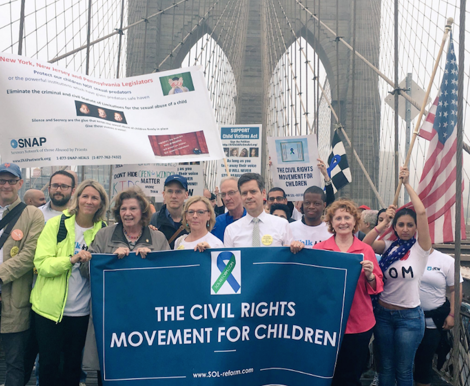 State Senator Brad Hoylman, center, holding banner, and other advocates marched across the Brooklyn Bridge earlier this month in support of a bill to lift the statute of limitations on child sex-abuse lawsuits.